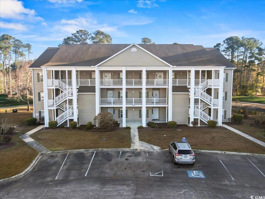 View of building exterior featuring uncovered parking and stairway