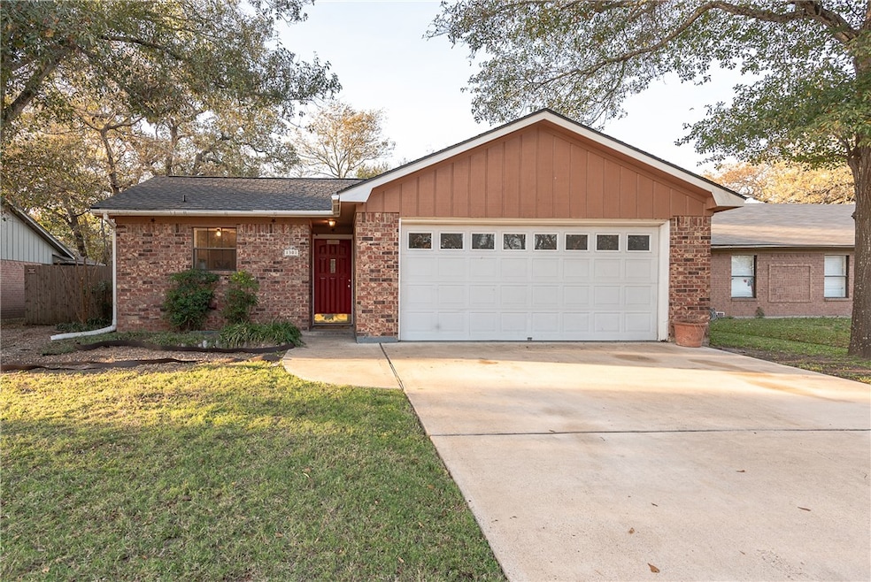 Ranch-style house featuring brick siding, concrete driveway, a front lawn, and a shingled roof