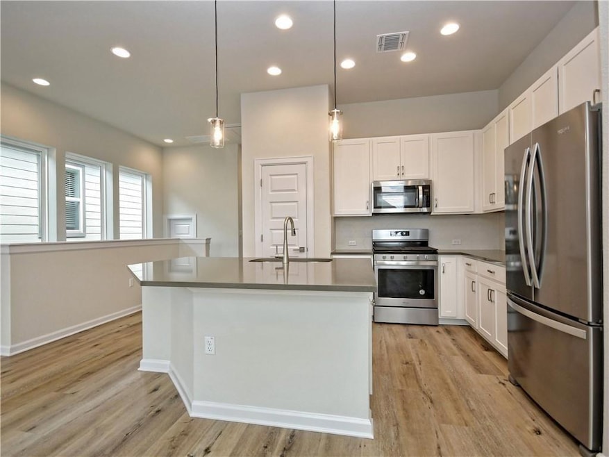 Kitchen with visible vents, light wood-style floo