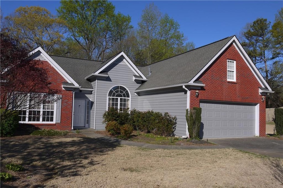 View of property featuring a front lawn and a gara