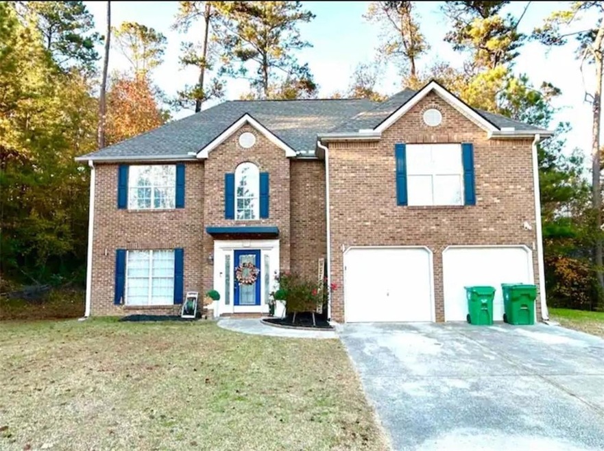 View of front of home with a front yard and a gara