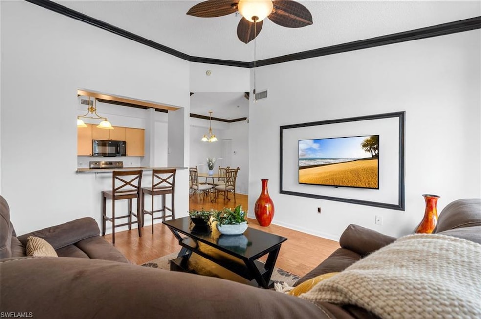 Living area with crown molding, ceiling fan, and wood finished floors