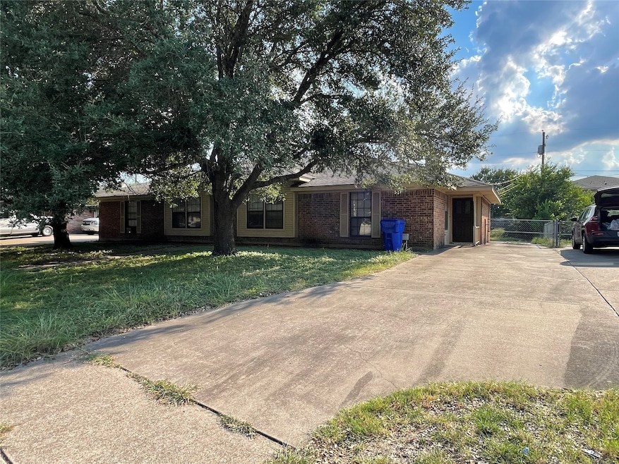 Ranch-style home featuring brick siding, a front lawn, and driveway