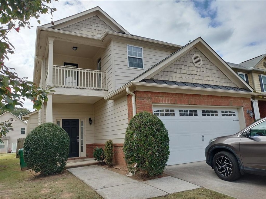 View of front of home featuring a balcony and a ga