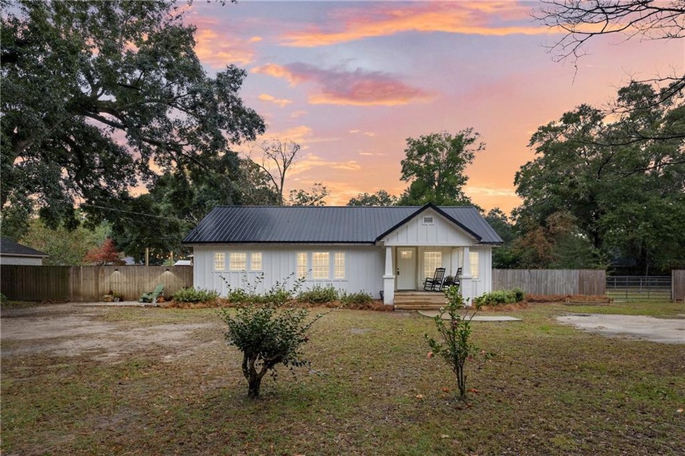 View of front of house with a lawn and covered por