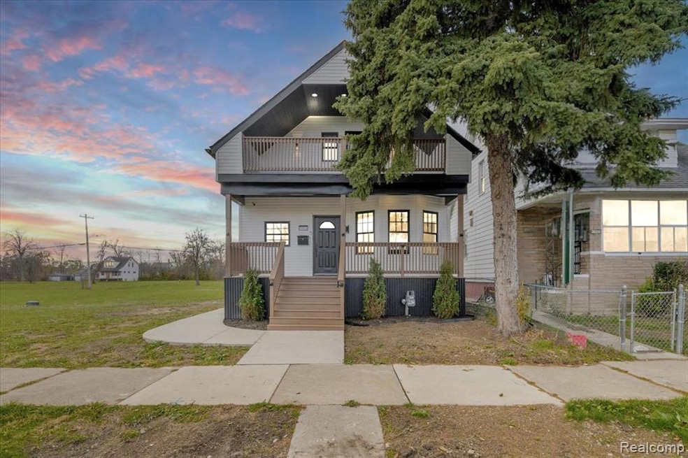View of front of home featuring a porch, a yard, a balcony, and a gate