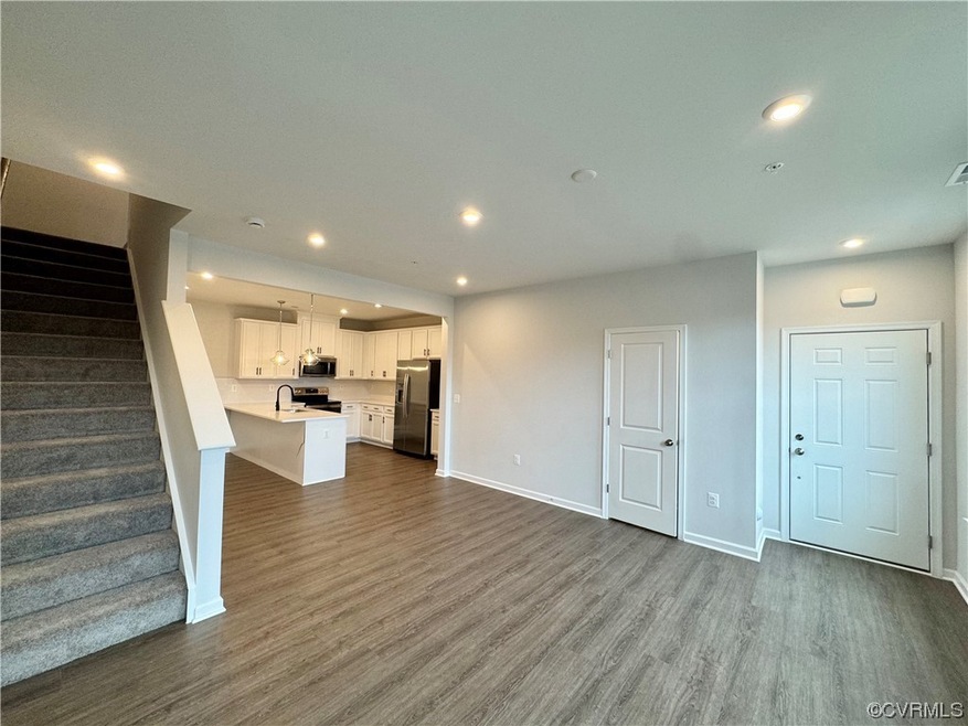 Unfurnished living room featuring dark hardwood / wood-style flooring and sink