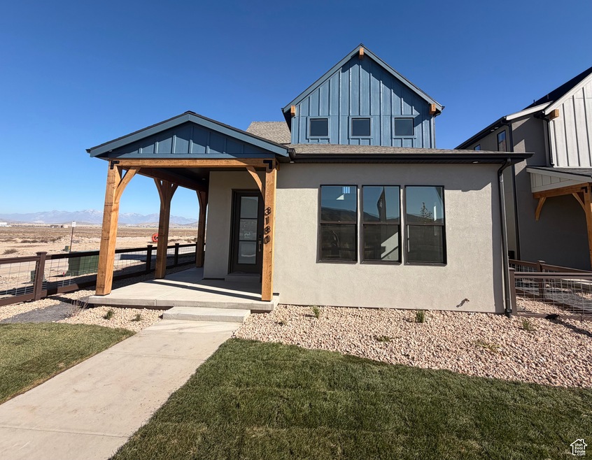 View of front of property featuring stucco siding, board and batten siding, and a mountain view