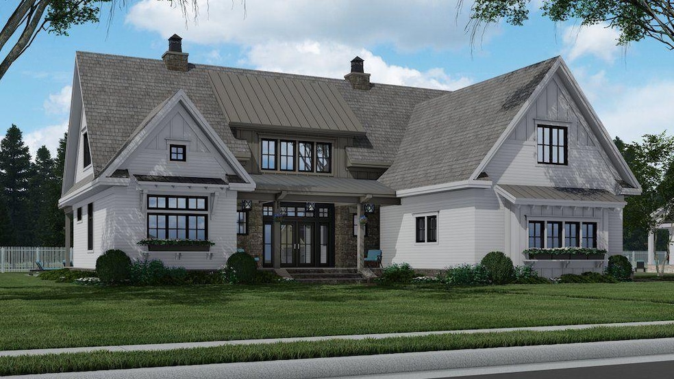 View of front facade with a standing seam roof, a front yard, a chimney, and a metal roof