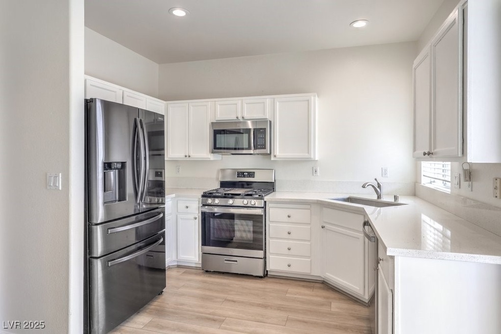 Kitchen featuring a sink, light wood finished floo