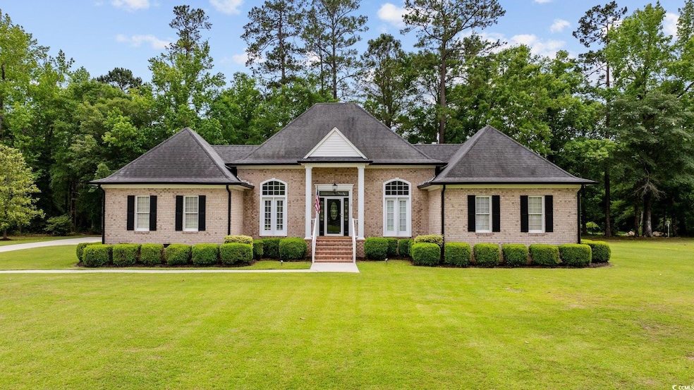 View of front facade featuring a front lawn, brick siding, and a shingled roof