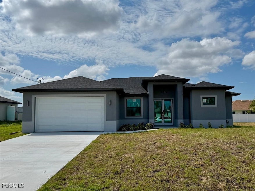 Prairie-style home with a front yard, stucco siding, an attached garage, concrete driveway, and a shingled roof