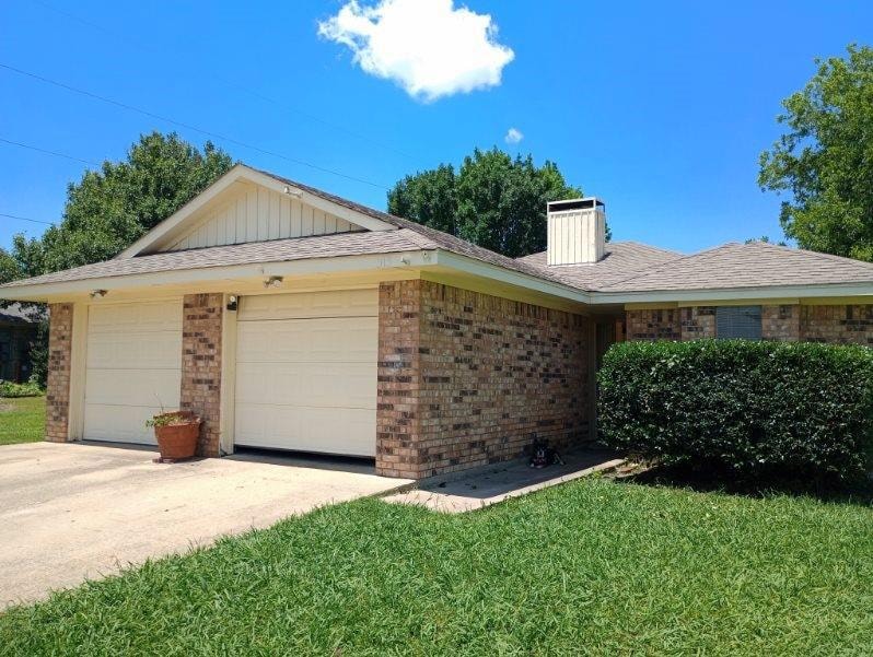 Ranch-style Duplex featuring a front lawn and a ga