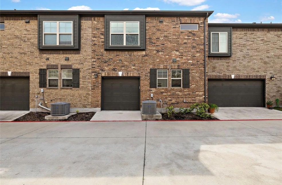 View of front facade with brick siding and driveway