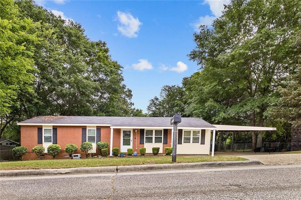 Single story home featuring fence, a carport, driv