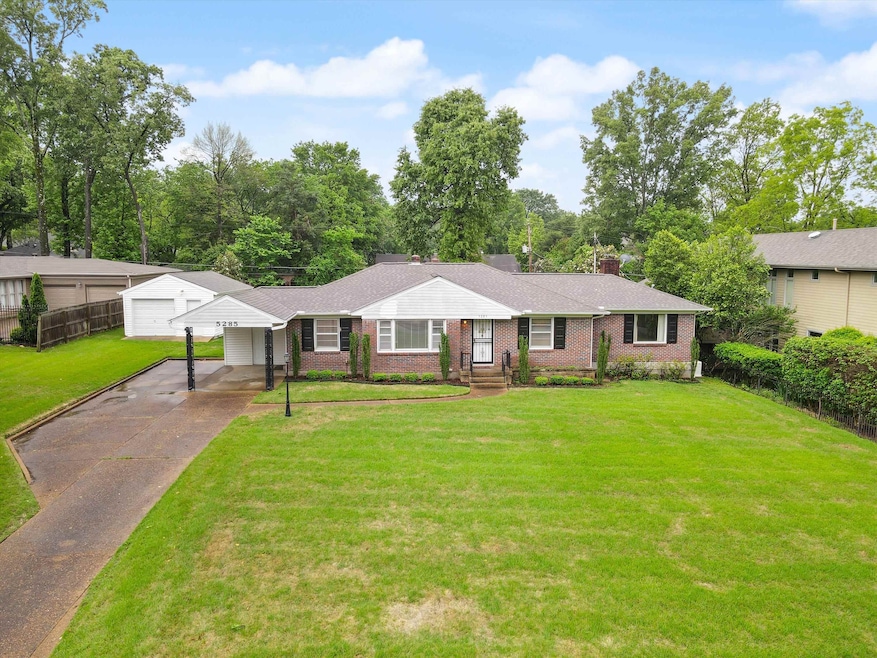 Single story home featuring a front yard, driveway, brick siding, and a chimney