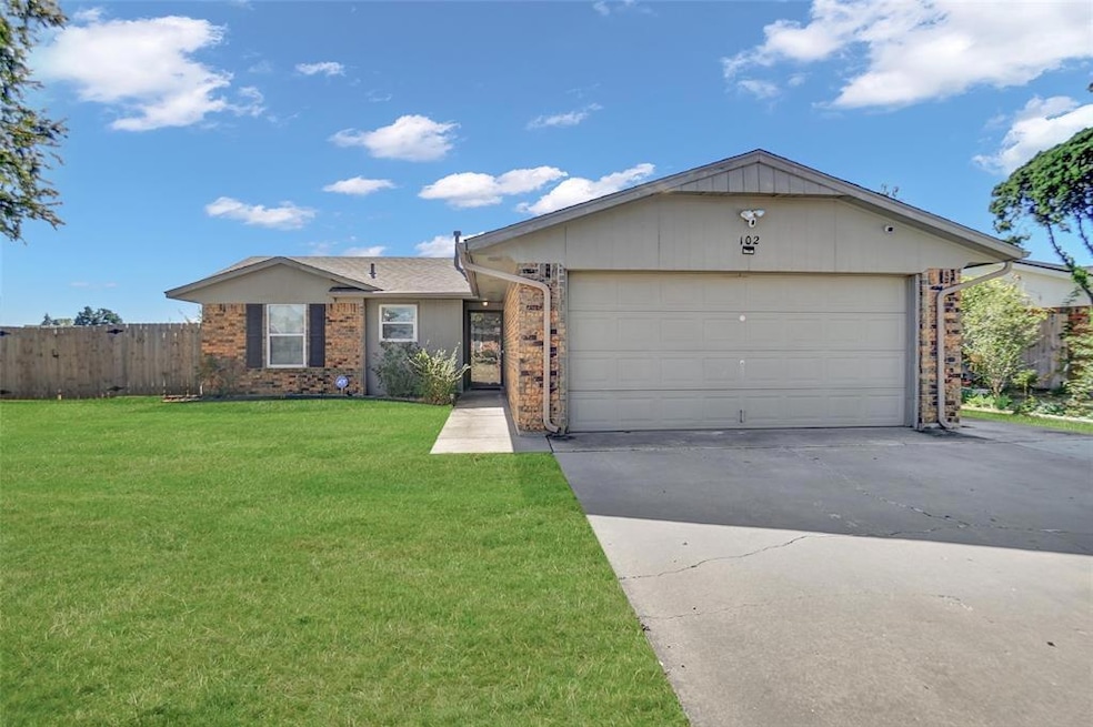 Single story home with a garage and a front lawn