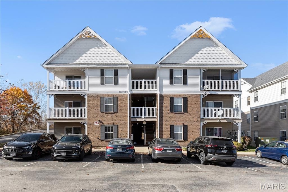 View of property featuring uncovered parking