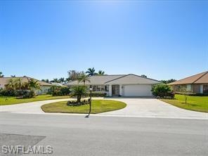 Single story home with a front yard and a garage