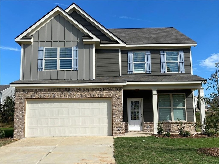 Craftsman-style house featuring brick siding, board and batten siding, a garage, and concrete driveway
