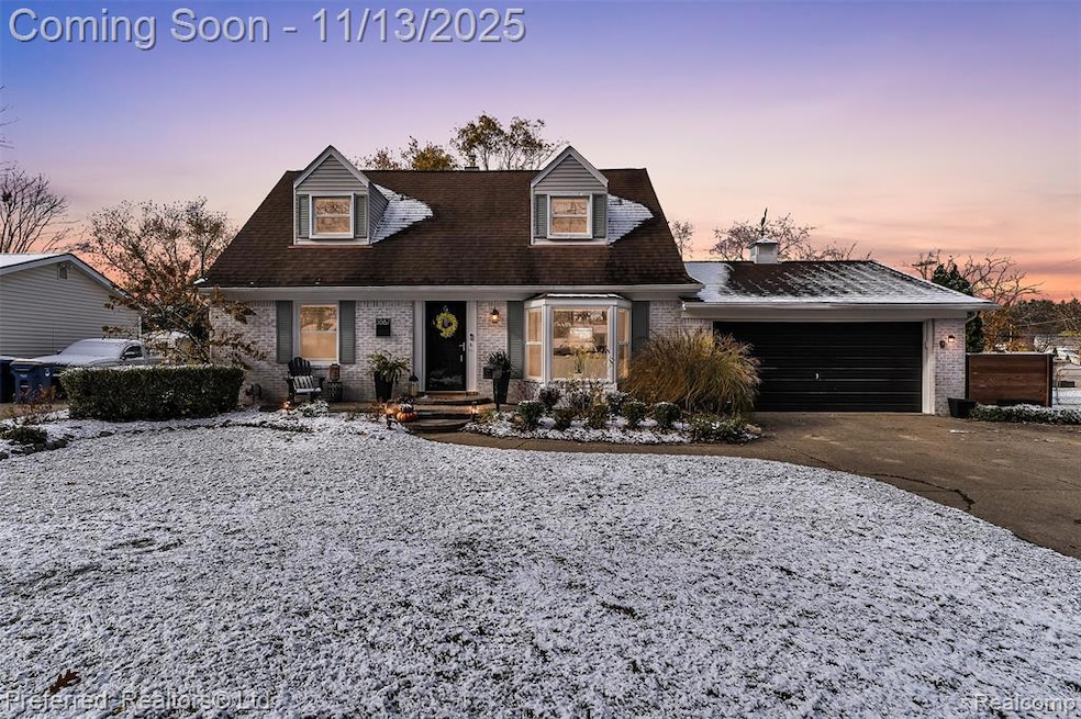 Cape cod house with brick siding, concrete driveway, a garage, and a chimney
