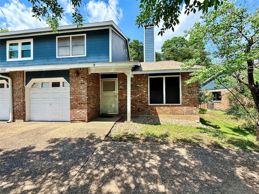 View of front of property featuring a garage, bri