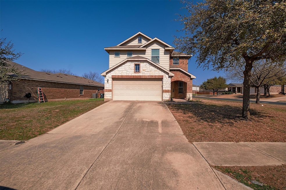 View of front of property with a front yard, a ga