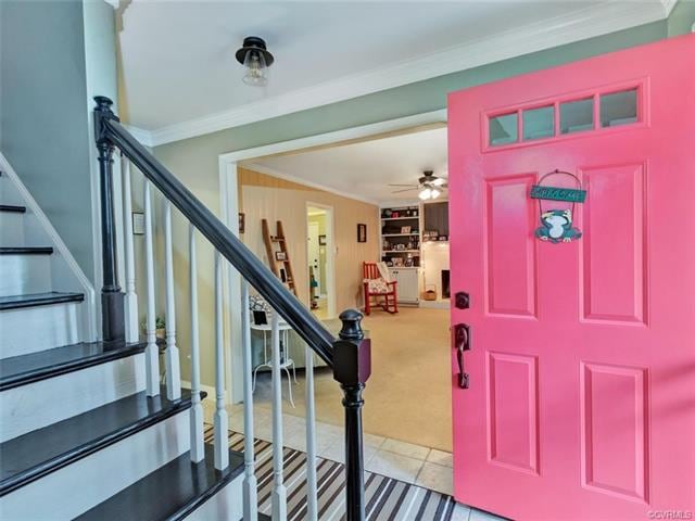 Front entry foyer with updated lighting, wooden stairs, tile entry and open to family room.