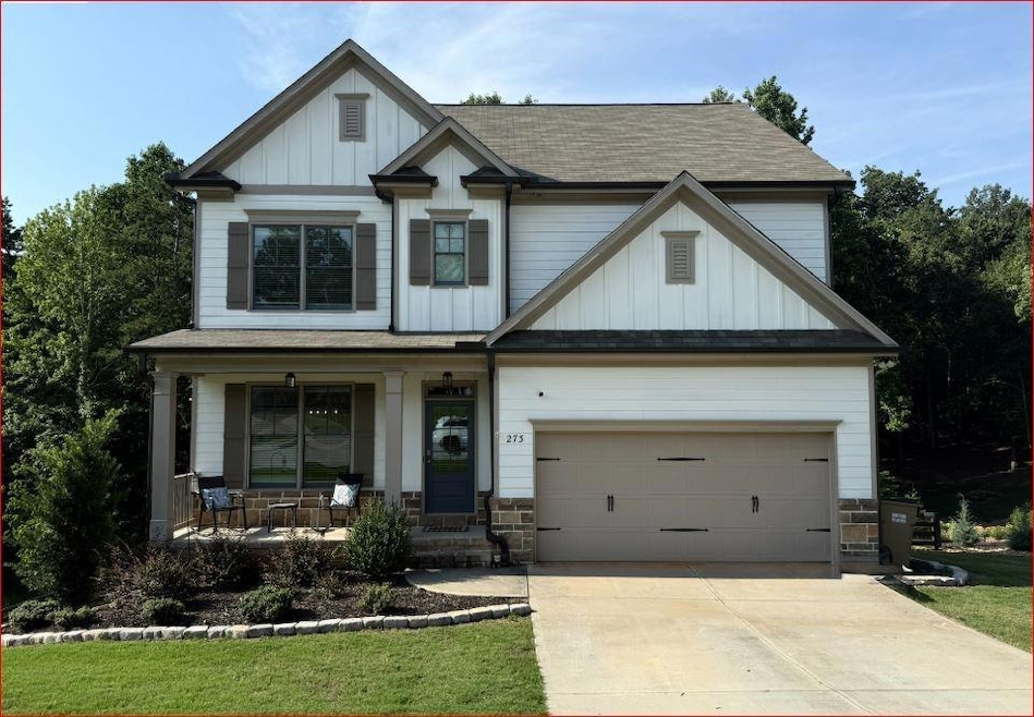 Craftsman-style house with covered porch, board and batten siding, concrete driveway, roof with shingles, and stone siding