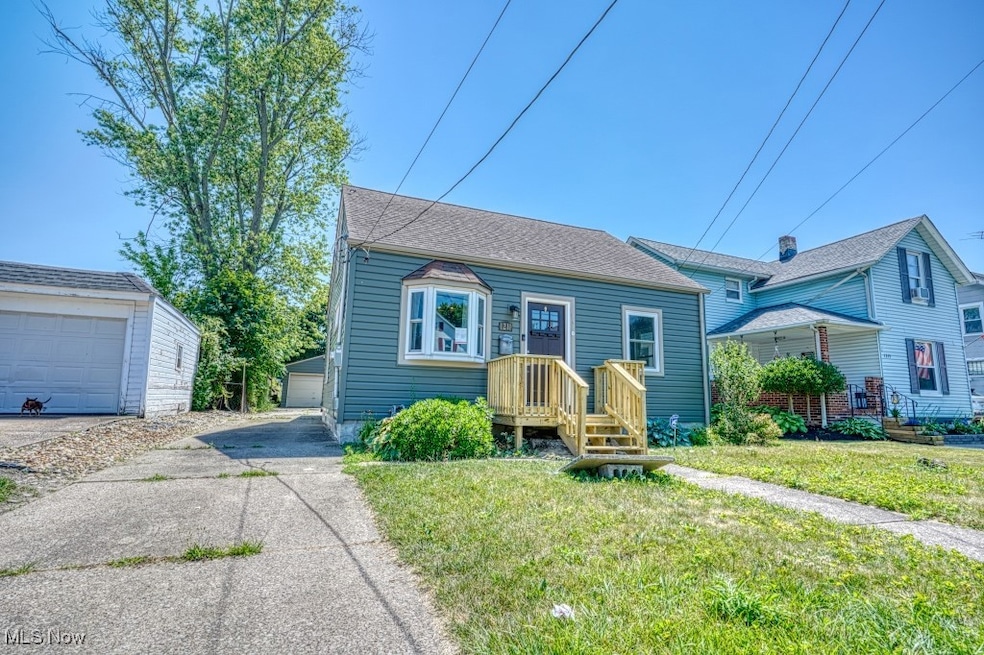 Bungalow-style home featuring an outbuilding, a front lawn, and roof with shingles
