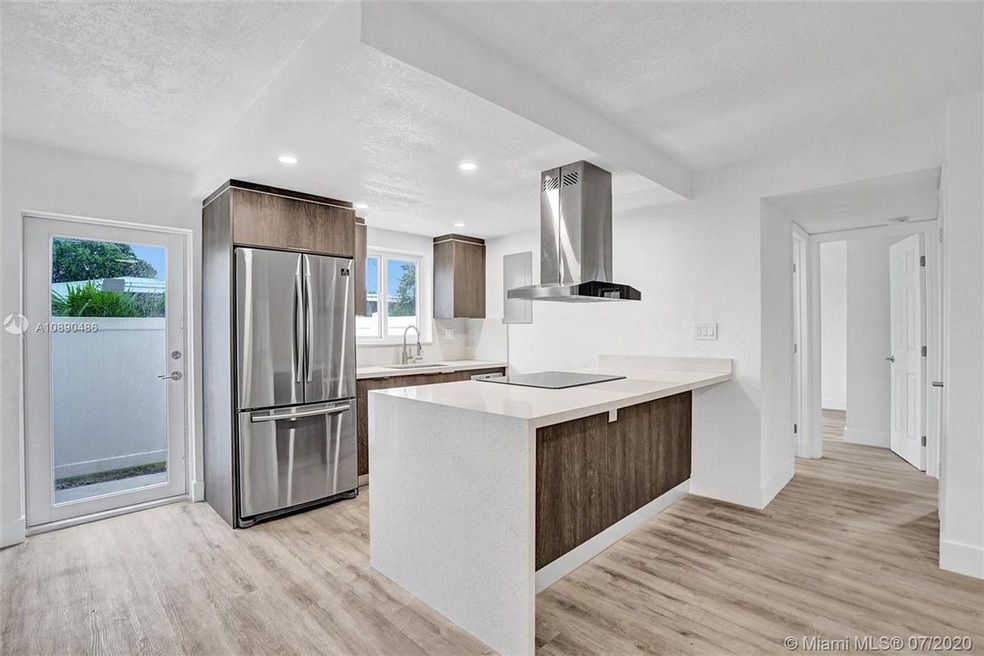 Kitchen with quartz waterfall edge, soft close drawers, new stainless steel appliances.