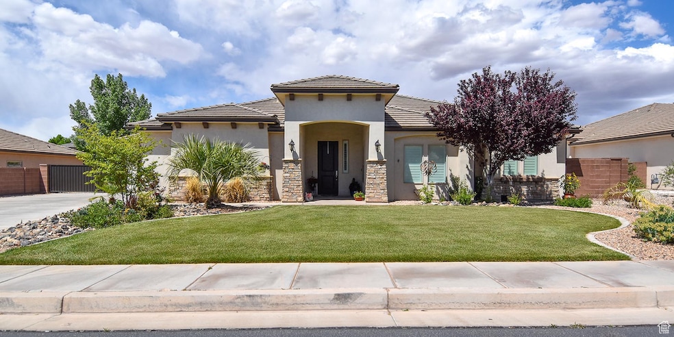 View of front of property with stucco siding, driveway, a tiled roof, and a front yard