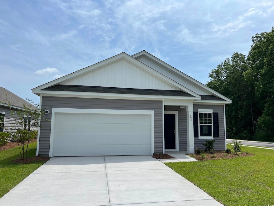 Ranch-style home featuring driveway, a front yard, and a garage