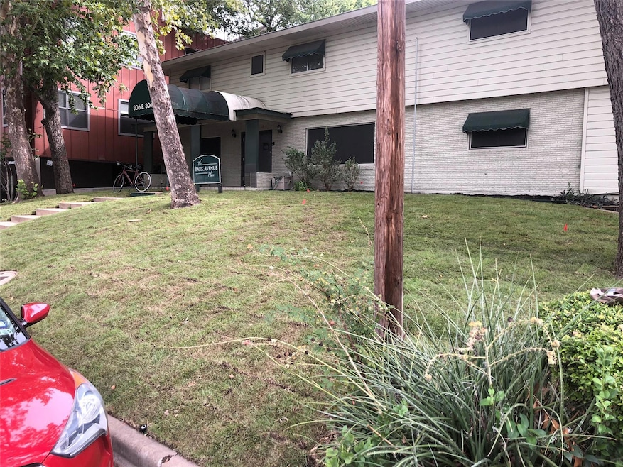 View of front facade with a front yard and brick 