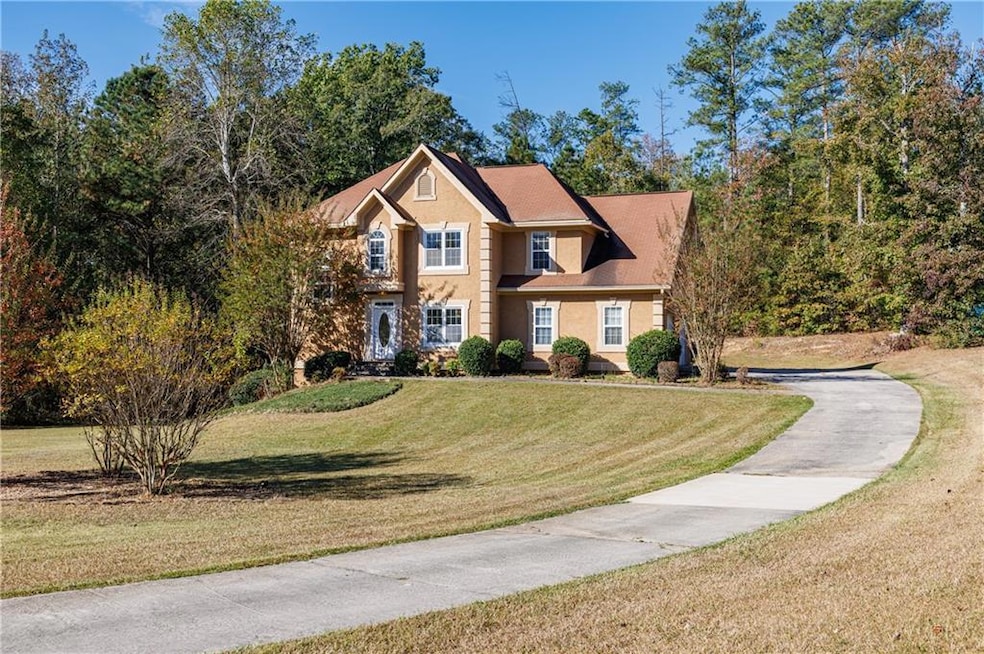 Colonial-style house with a front yard, stucco siding, and roof with shingles