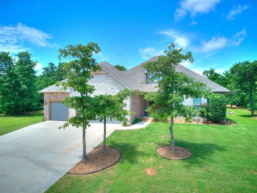 View of front of house featuring concrete driveway, brick siding, a front yard, and an attached garage