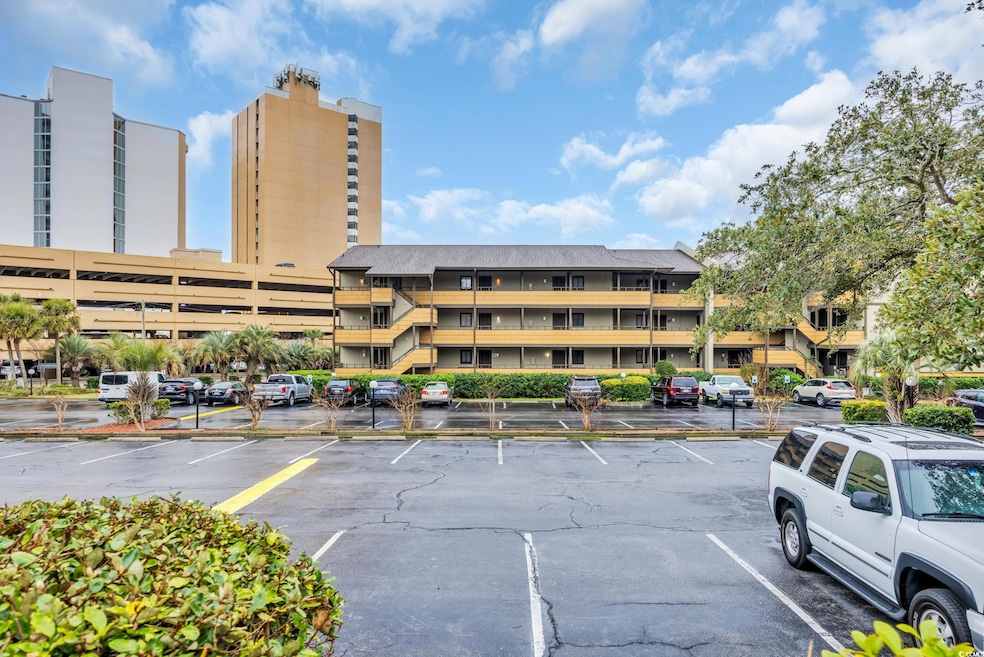 View of building exterior with uncovered parking