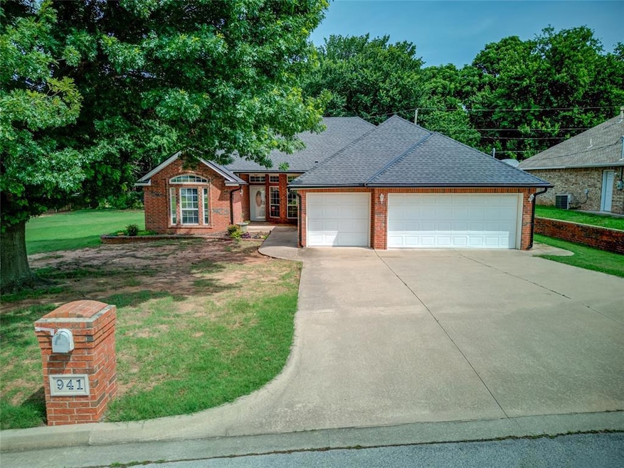 View of front of house featuring brick siding, a front yard, concrete driveway, an attached garage, and a shingled roof