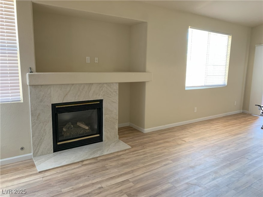Unfurnished living room featuring a fireplace, woo