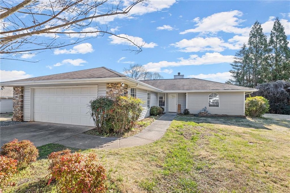 Single story home featuring a front lawn and a gar