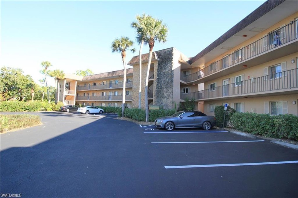 View of apartment building / complex with uncovered parking