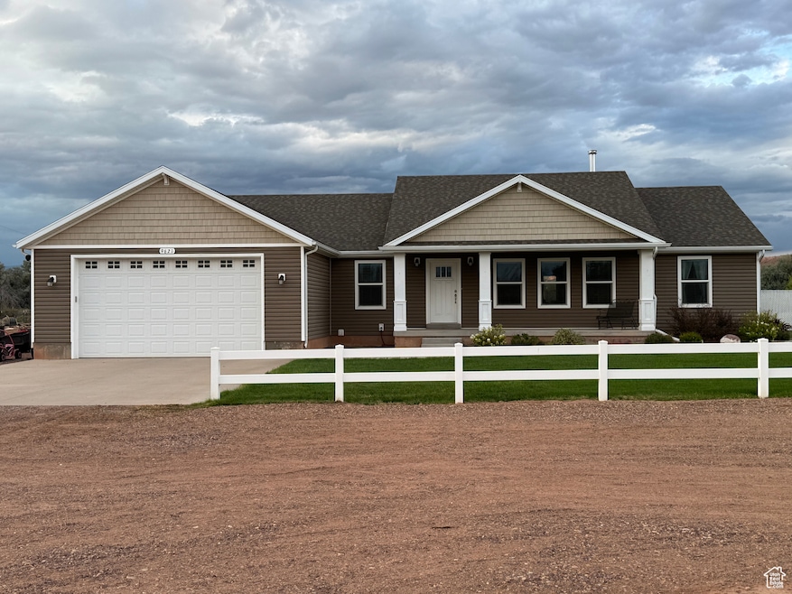 Craftsman-style home with a porch, a shingled roof, driveway, and a garage