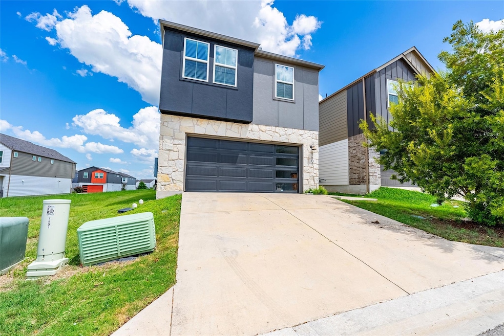 Contemporary home featuring stone siding, an atta