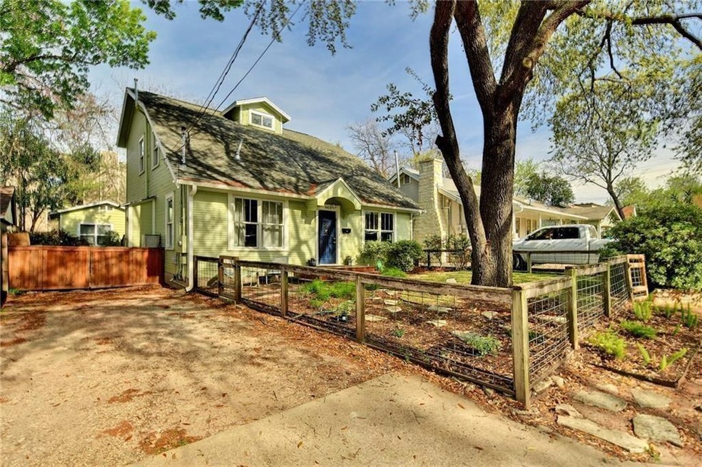 View of front of property with a fenced front yard, a gambrel roof, and a gate