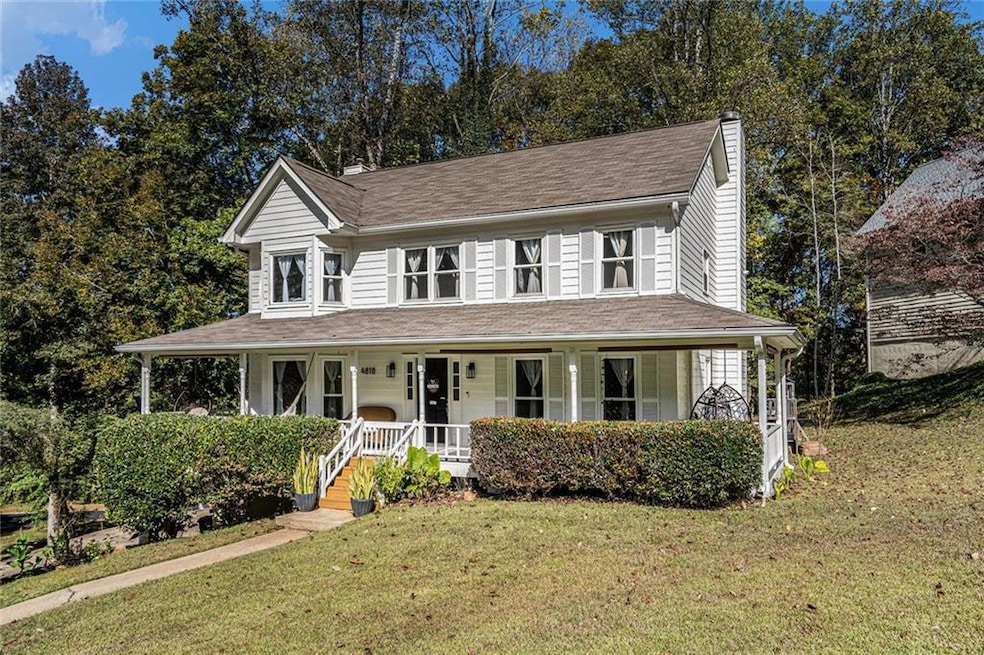 Farmhouse-style home featuring a front yard, covered porch, a chimney, and roof with shingles