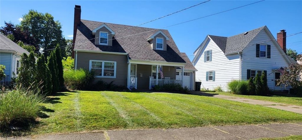 Cape cod house featuring a porch and a front lawn