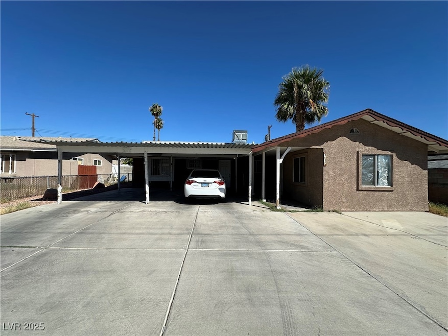 Ranch-style house with an attached carport, driveway, and stucco siding