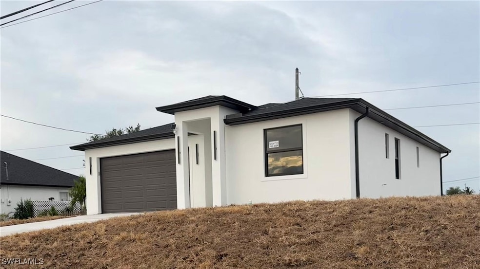 View of front of home with stucco siding and a gar