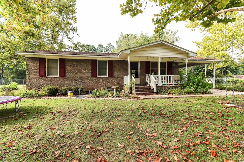 Ranch-style home with a front yard and covered por