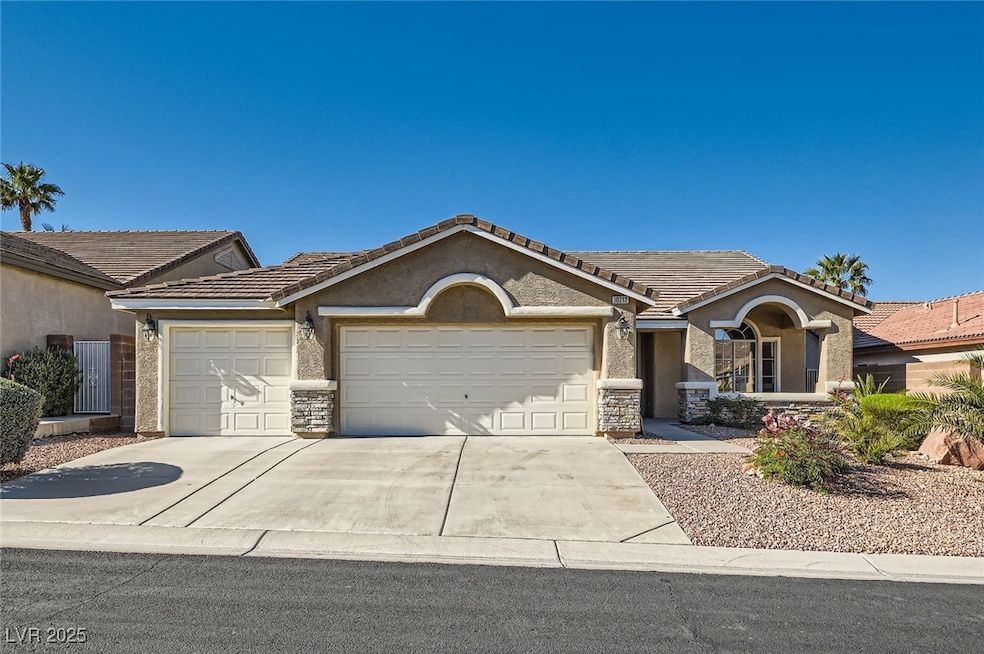 Ranch-style home with an attached garage, stone si